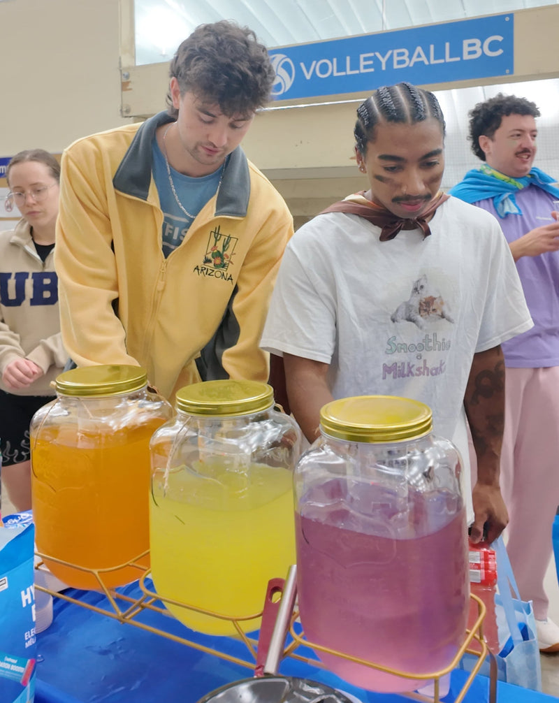 Players filling cups from Nutrazul hydration jars at the Ninja Volleyball tournament